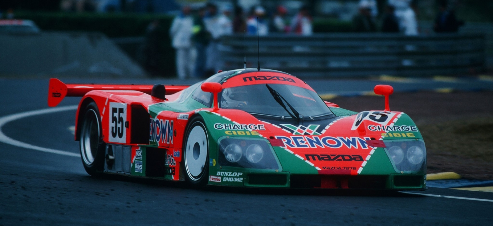 Legendarna trkačka Mazda 787B sa narandžasto-zelenom Renown grafikom na stazi Le Mans, jedini pobednik sa rotacionim motorom