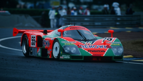 Legendarna trkačka Mazda 787B sa narandžasto-zelenom Renown grafikom na stazi Le Mans, jedini pobednik sa rotacionim motorom
