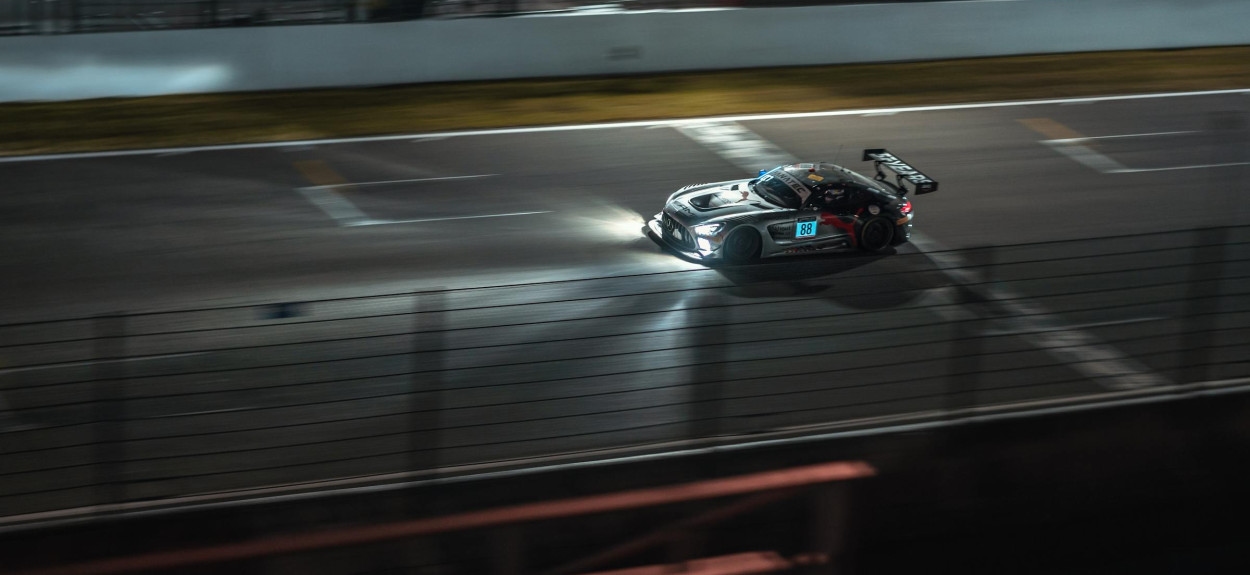 Moderni trkački bolid pod reflektorima tokom noćne smene na trci 24 sata Le Mana, prikazujući aerodinamiku i brzinu