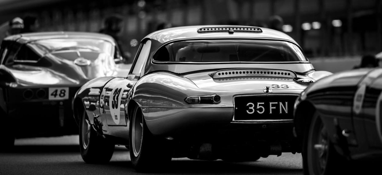 Crno-beli prikaz klasičnih sportskih automobila na stazi Circuit de la Sarthe tokom rane ere 24 sata Le Mana