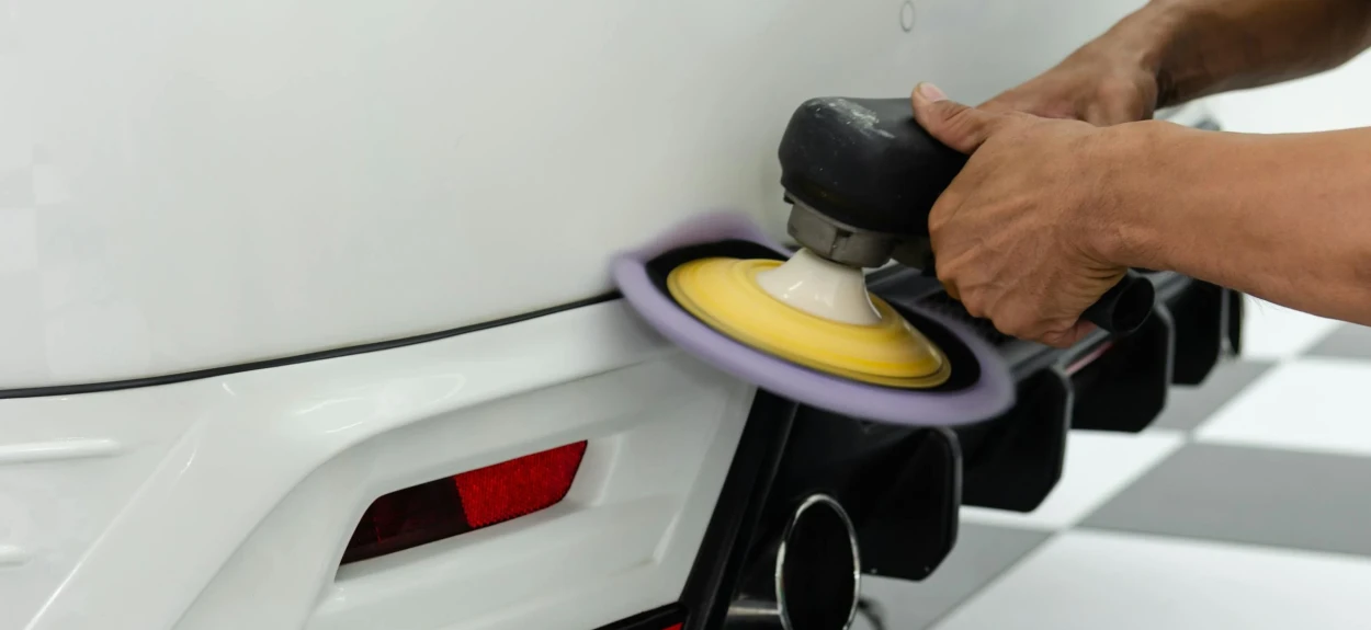 Poliranje belog automobila završni radovi na zadnjem delu vozila.